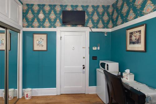 a room with blue walls and a door with a tv on the wall at Prince Street Suites in Charlottetown