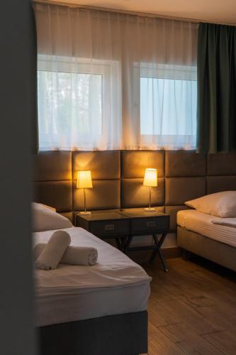 a hotel room with two beds and two windows at Przystanek Zatoka in Olsztyn