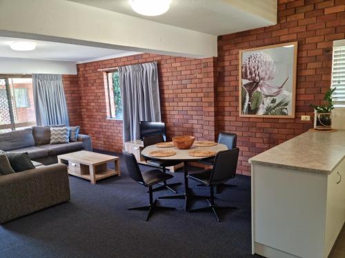a living room with a table and a couch at Whiteoaks Motel & Lodges in Toowoomba