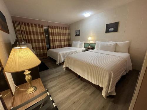 a hotel room with two beds and a lamp at Holiday House Motel in Ladysmith
