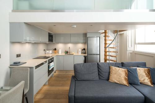 a living room with a blue couch in a kitchen at Kensington Arte Casa in London