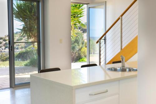 a kitchen with a sink and a large window at Shearwaters Apartment Waterfront Accomodation in Penneshaw