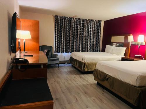 Pokój hotelowy z 2 łóżkami i biurkiem w obiekcie Mountain Inn w mieście Iron Mountain