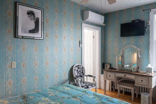 a bedroom with a bed and a desk and a mirror at Prince Street Suites in Charlottetown