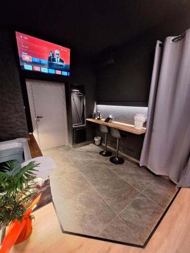 a room with a table and a tv on the wall at Dark & Light rooms & luxury suites in Catania