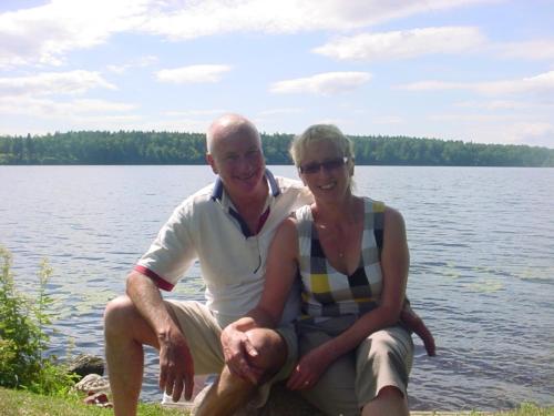 a man and a woman sitting next to a lake at Ligita's Homestay in Havelock