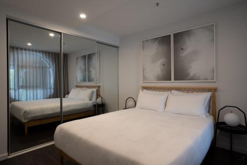 1 dormitorio con 2 camas y espejo en Perfect Central Located 2-Bed with Secure Parking, en Canberra