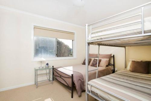 a bedroom with two bunk beds and a window at Ships Ahoy in Kiama