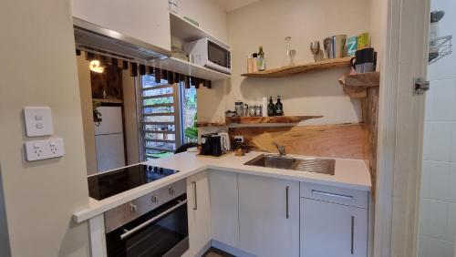 a small kitchen with a sink and a stove at Kashikiri- Adelaide Hills Private Japanese Bath Retreat- pre-finished special in Crafers