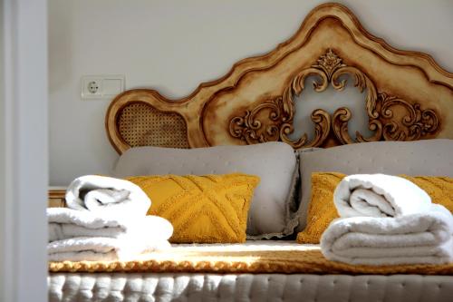 un letto con asciugamani e cuscini sopra di La casita de Fide a Molinaseca