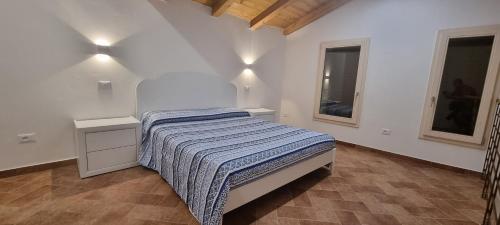 - une chambre blanche avec un lit et 2 fenêtres dans l'établissement Corte Malvezzi, à Castel Guelfo di Bologna
