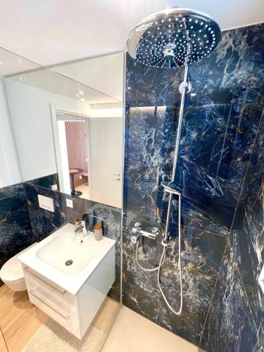 a bathroom with a sink and a shower and a toilet at Lake Star in Brissago