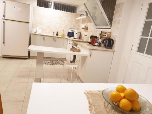 a kitchen with a bowl of fruit on a table at Spacious and Peaceful 2BD with a Garden & Parking in Gan H̱ayyim