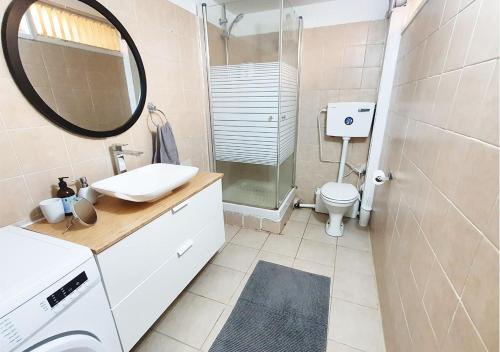 a bathroom with a sink and a shower and a toilet at Spacious and Peaceful 2BD with a Garden & Parking in Gan H̱ayyim
