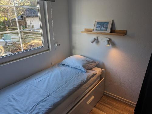 Dormitorio pequeño con cama junto a una ventana en Mini-villa 200 m from Kämpinge beach en Höllviken