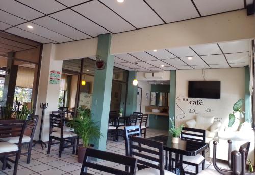 un restaurante con mesas y sillas y TV en la pared en Hotel Fragata en San Juan Bautista Tuxtepec