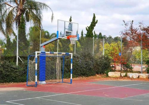a basketball hoop on a tennis court at Spacious and Peaceful 2BD with a Garden & Parking in Gan H̱ayyim