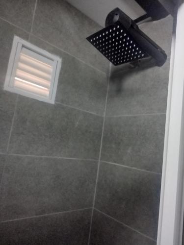 een badkamer met een betegelde douche en een raam bij Hotel la cava del chef in Paipa