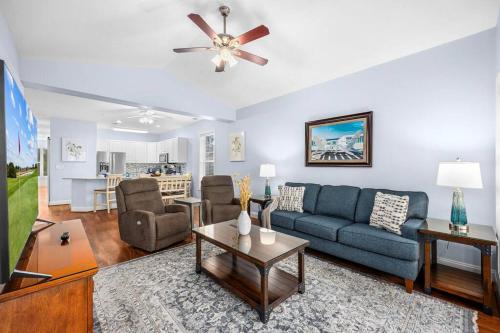 ein Wohnzimmer mit einem blauen Sofa und einem TV in der Unterkunft Gorgeous 3BR 3BA Villa W/Amazing Views Near Beach in Myrtle Beach
