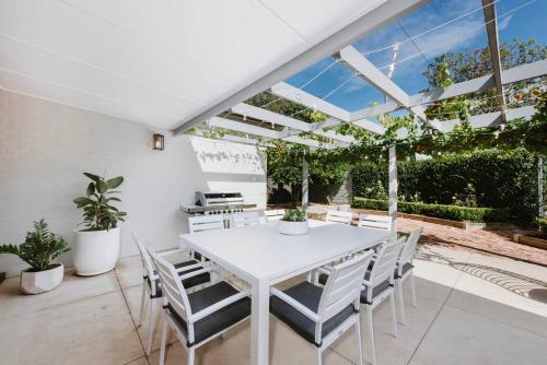 un comedor blanco con una mesa y sillas blancas en 'Haylock' Luxe Country Charm in Mudgee's Centre en Mudgee