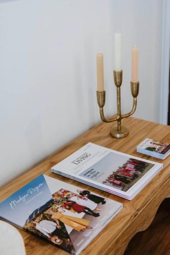 a table with two books and two candles on it at 'Haylock' Luxe Country Charm in Mudgee's Centre in Mudgee