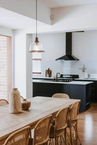 a kitchen with a large wooden table with chairs at 'Haylock' Luxe Country Charm in Mudgee's Centre in Mudgee