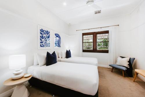 a white bedroom with two beds and a window at 'Haylock' Luxe Country Charm in Mudgee's Centre in Mudgee