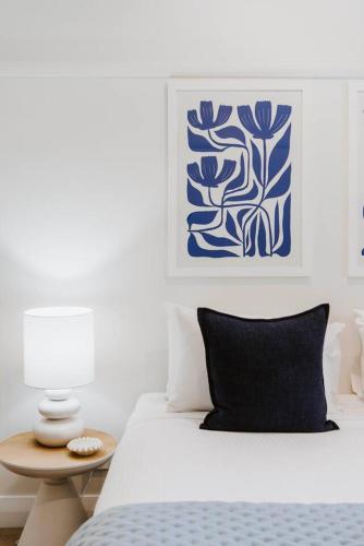 a bedroom with a bed with a blue and white painting at 'Haylock' Luxe Country Charm in Mudgee's Centre in Mudgee