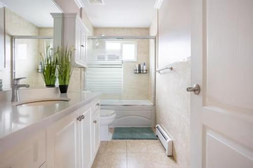a bathroom with a sink and a toilet and a shower at Jane's private rooms with shared washroom in Surrey