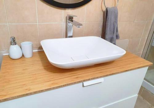 a white sink on a wooden counter in a bathroom at Spacious and Peaceful 2BD with a Garden & Parking in Gan H̱ayyim