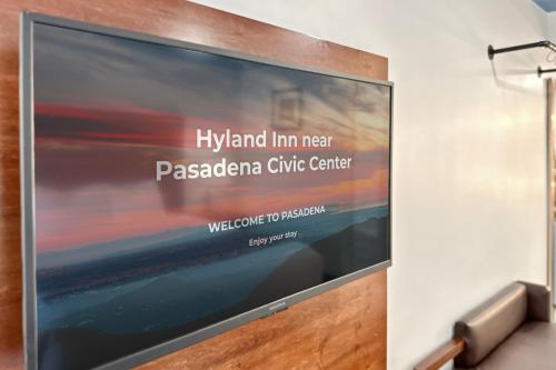 a large screen tv on a wall with the words hyland inn next pasadena at Hyland Inn near Pasadena Civic Center in Pasadena