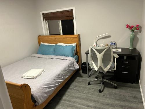 a bedroom with a bed with a desk and a chair at Cozy room D in Kitchener