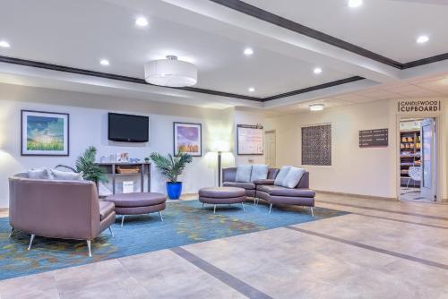 a waiting room with couches and chairs and a tv at Candlewood Suites Fort Worth West by IHG in Fort Worth