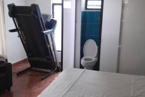 a bathroom with a toilet and a tv in a room at casa mangos in Temixco