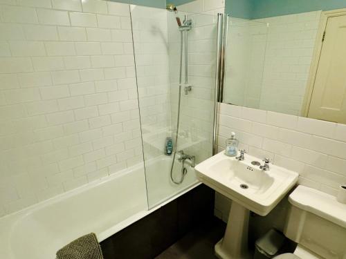 a white bathroom with a sink and a shower at Harrington Suites in London