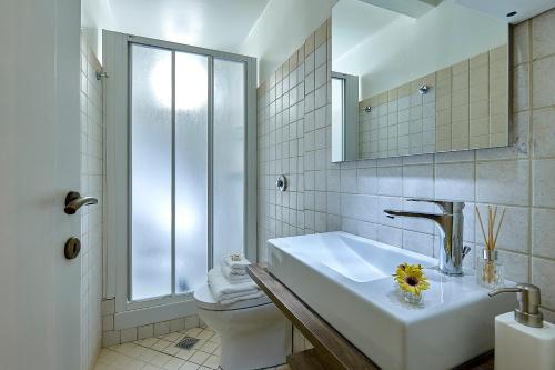 a white bathroom with a sink and a toilet at Erato Vintage House (city center) in Heraklio Town