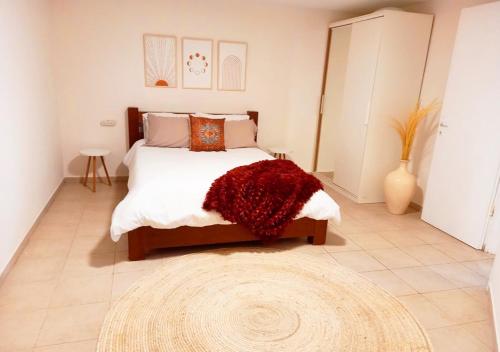 um quarto com uma cama grande e um tapete vermelho em Spacious and Peaceful 2BD with a Garden & Parking em Gan H̱ayyim