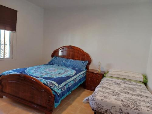 1 dormitorio con 1 cama y mesita de noche al lado en Casa Rural la Ruta del Vino Zarcilla de Ramos, en Lorca