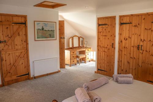 a bedroom with wooden walls and wooden doors and a bed at Arthurs Cottage - rural hideaways in Norfolk in Edingthorpe