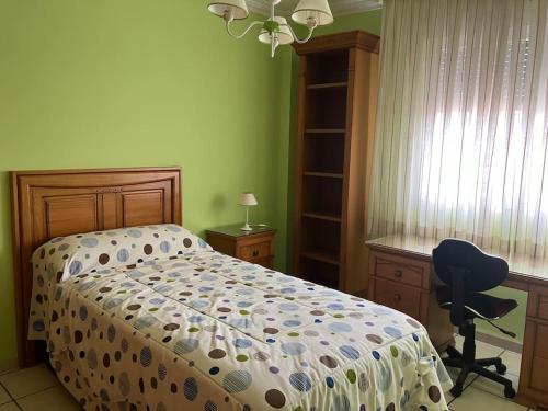 1 dormitorio con cama, escritorio y silla en Piso céntrico en Hellin, en Hellín