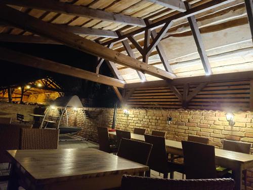 a restaurant with wooden tables and chairs and a brick wall at Penzion Starovice in Starovice