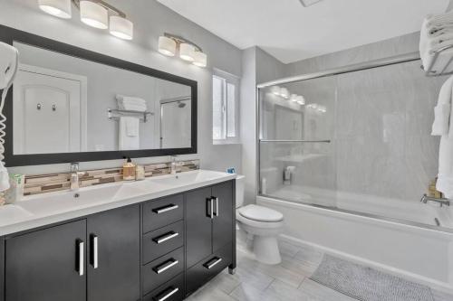 a bathroom with a tub and a toilet and a sink at New cheerful villa, Pool, Spa, Mini Golf, Game room, Fire pit next to Disneyland in Anaheim