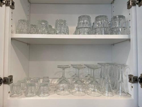 a bunch of glasses sitting on shelves in a cabinet at New cheerful villa, Pool, Spa, Mini Golf, Game room, Fire pit next to Disneyland in Anaheim