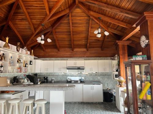 cocina con armarios blancos y techo de madera en La Casa de Pia, en Baños