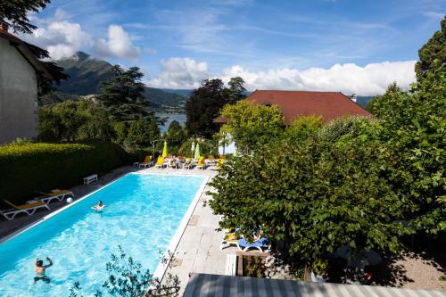une vue aérienne d'une piscine dans un complexe hôtelier dans l'établissement Hotel du Lac, à Talloires