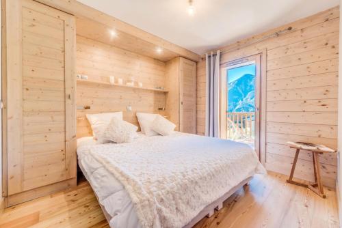 um quarto com uma cama e uma grande janela em Résidence Les Balcons EtoilÉs - 3 Pièces pour 6 Personnes 301 em Champagny-en-Vanoise