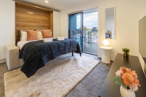 a bedroom with a bed and a large window at Urban Retreat at 8 Wilmer: Upper Level Studio Gem in Christchurch