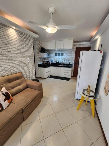 a living room with a couch and a kitchen at Prédio Frente Mar Praia da Costa 08 in Vila Velha