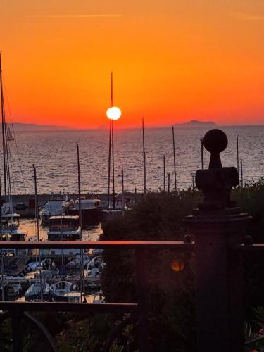a sunset over a marina with boats in the water at Casa Laura Follonica in Follonica