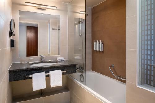 La salle de bains est pourvue d'un lavabo et d'une douche. dans l'établissement Courtyard by Marriott Paris La Defense West - Colombes, à Colombes